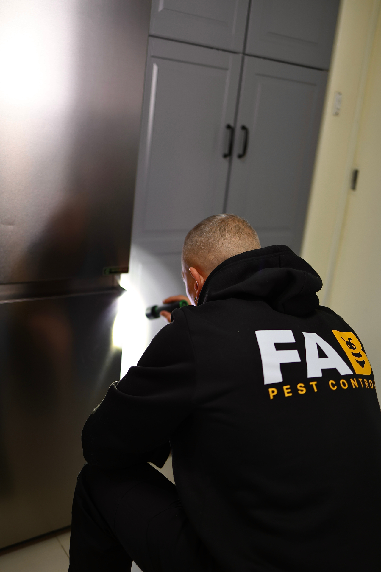 FAB Pest Control technician treating the exterior of a Perth home during spring pest season.